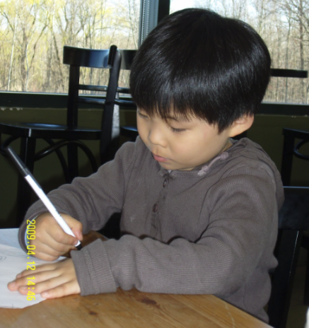 Kid drawing at a desk